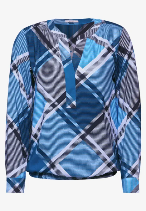 Blau-weiß gemusterte Bluse mit langen Ärmeln und auffälligem Karomuster.